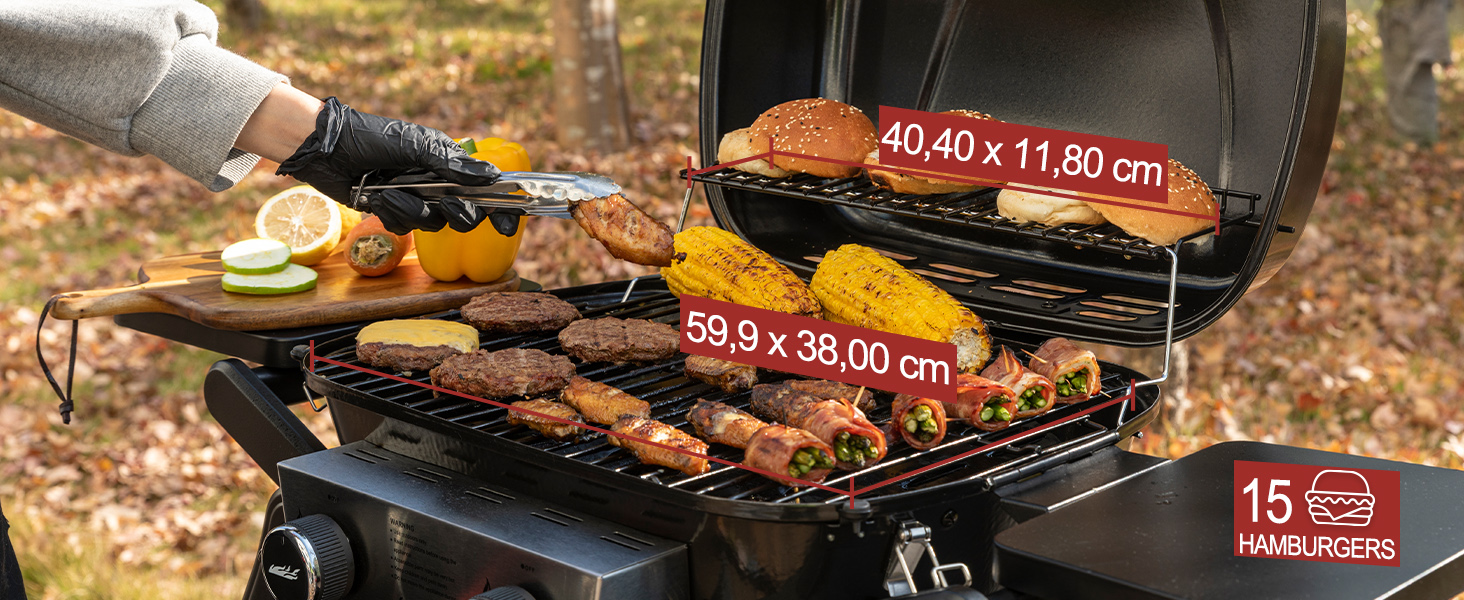 avec couvercle ouvert, avec deux niveaux de cuisson. La grille inférieure peut contenir diverses viandes et légumes, la grille supérieure contient des pains à hamburger. Dimensions indiquées pour les deux niveaux.