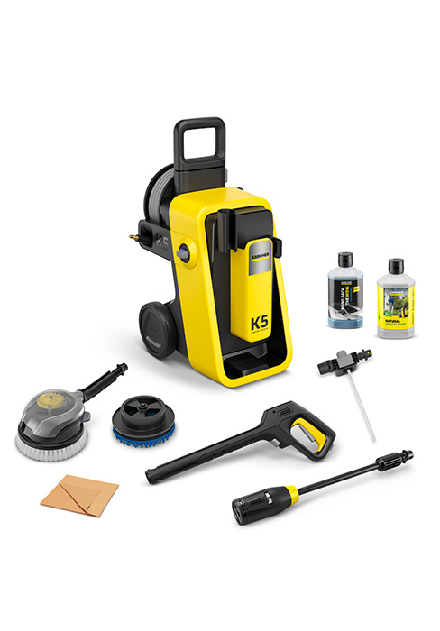 Ensemble de nettoyeur haute pression jaune avec accessoires comprenant un pistolet pulvérisateur, un nettoyeur de surface, des brosses et des bouteilles de solution de nettoyage disposés sur fond blanc.